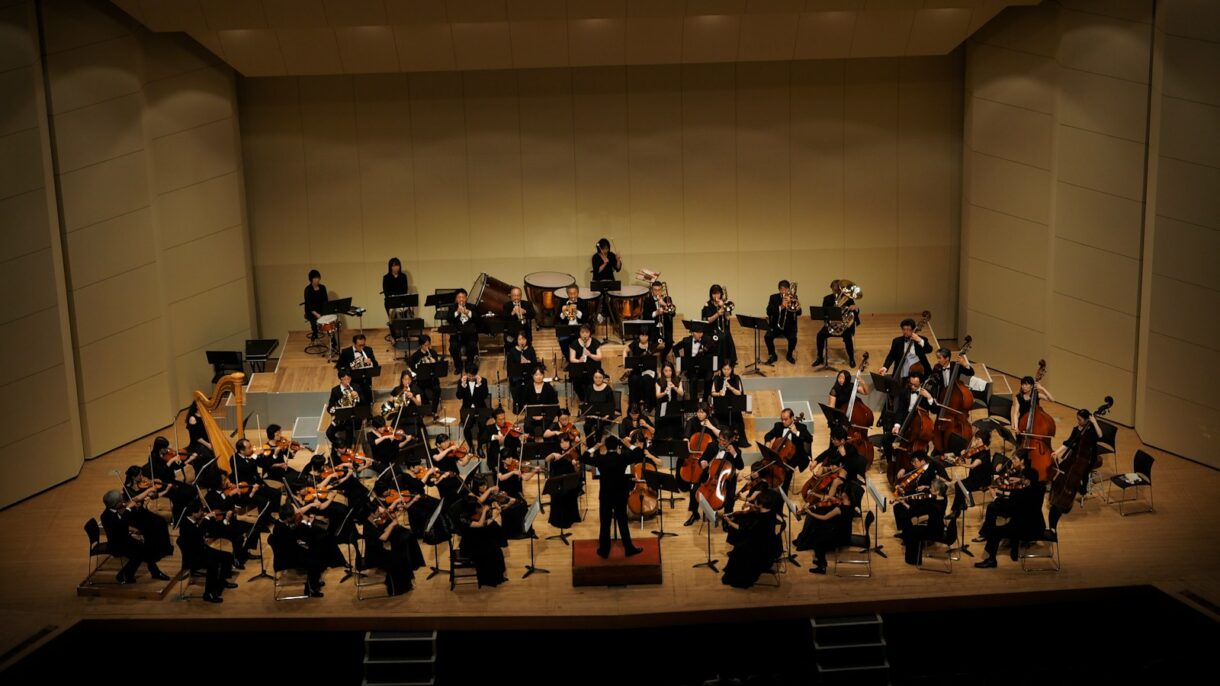 An orchestra is performing on a concert stage.